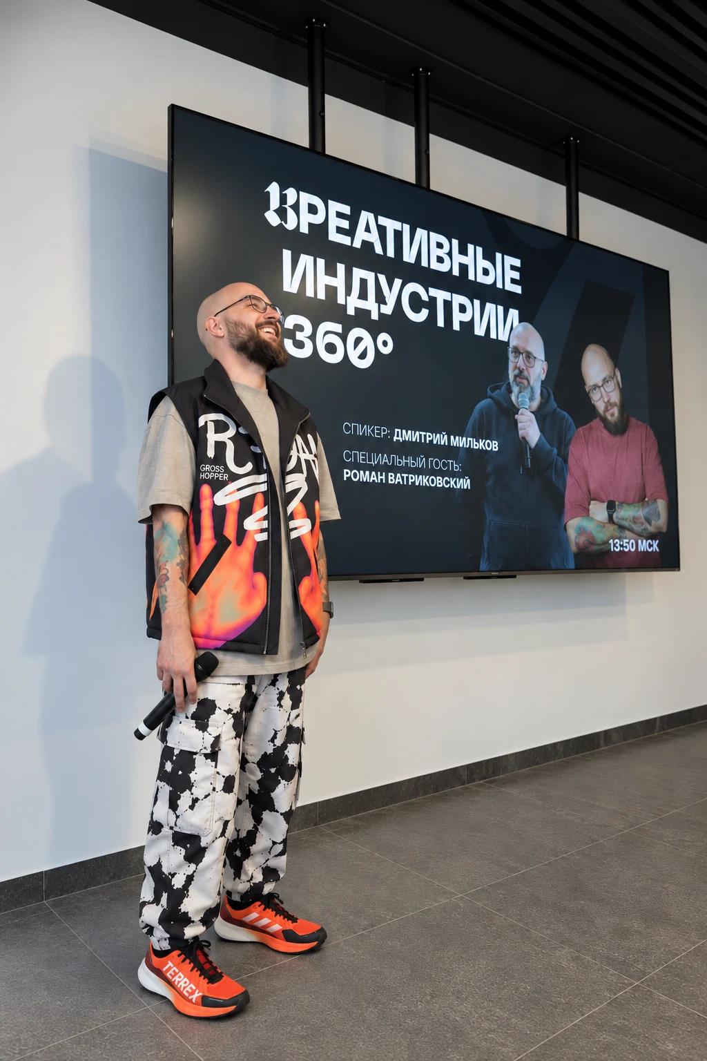 Roma Vatrikovsky holding a microphone at his Synergy talk